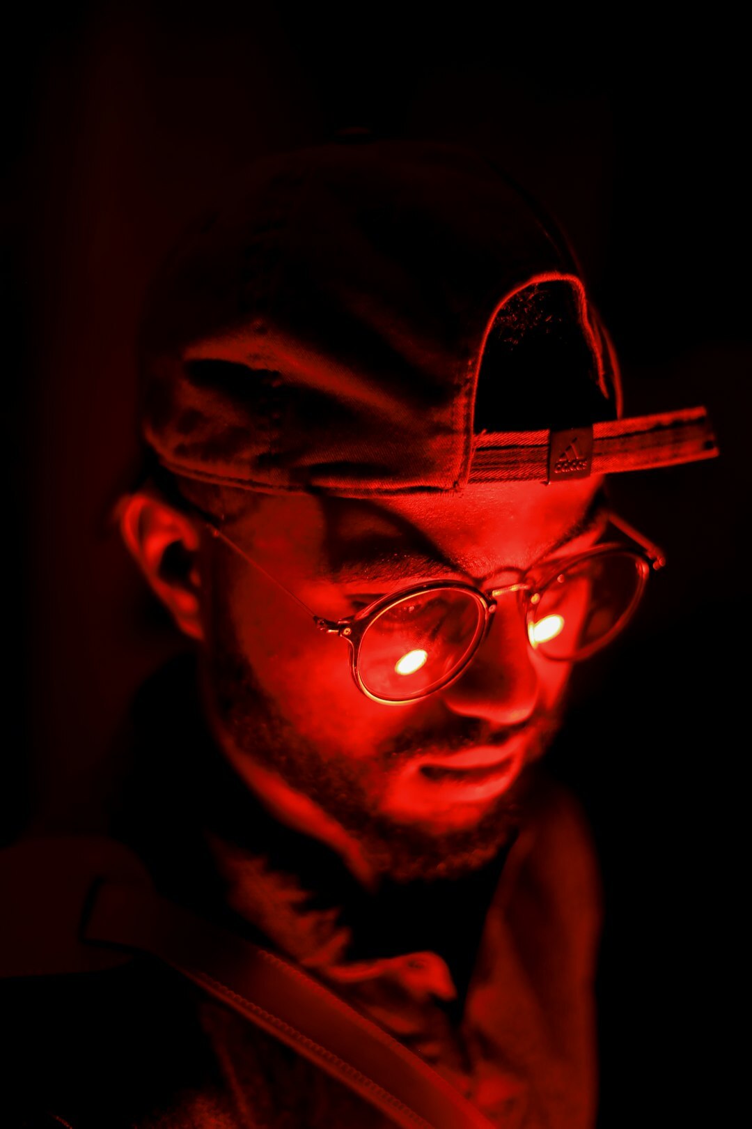Studio portrait of a male lighting technician with glasses