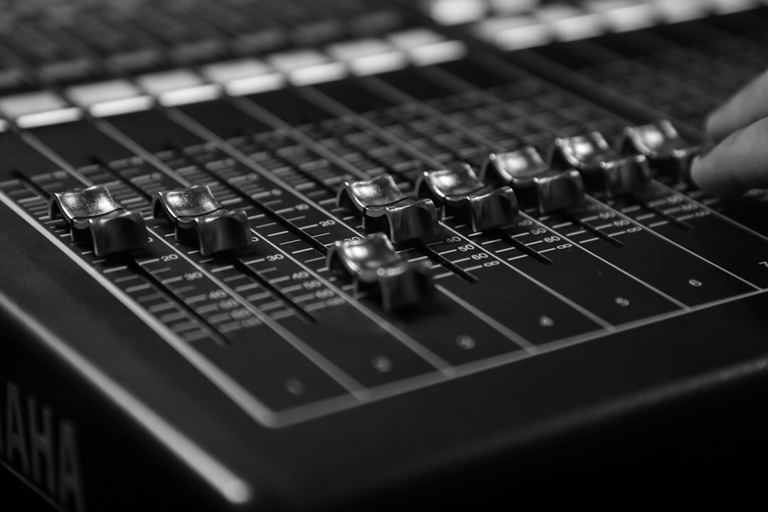 Professional audio mixing console with faders and knobs